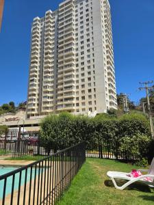 a large apartment building in front of a building at Playa Las Torpederas in Valparaíso