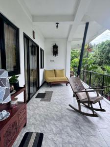 a porch with a bench and a couch on a balcony at Placido's Vacation Home in Puerto Galera