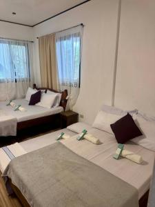 two beds in a hotel room with two at Placido's Vacation Home in Puerto Galera +74 photos