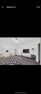 a living room with a ceiling fan and a television at Le Monye in Lewisville