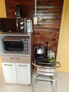 a small kitchen with a microwave and a table at Casa de descanso in Paredones +3 photos
