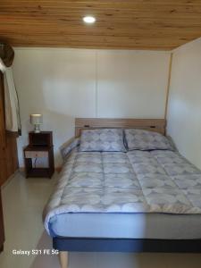 a bed in a bedroom with a wooden ceiling at Casa de descanso in Paredones