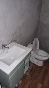 a bathroom with a white sink and a toilet at Casa de descanso in Paredones