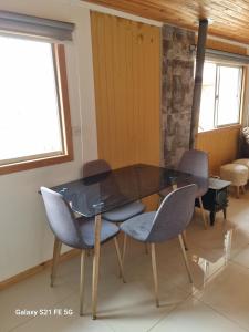 a dining room with a glass table and chairs at Casa de descanso in Paredones