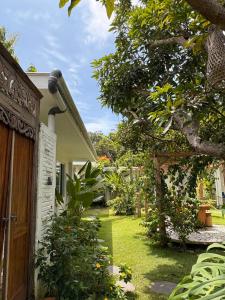 ein Haus mit einer Holztür und einem Hof in der Unterkunft Casa Della by Kahurangi in Sekongkang