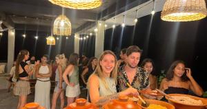 a man and a woman standing at a table with food at Salty Sand Hostel in Mirissa