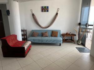 een woonkamer met een blauwe bank en een stoel bij Departamento en Playa Pulpos - 2 habitaciones - Piscina compartida in Arica