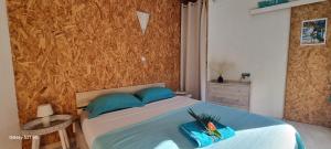 a bedroom with a bed with blue pillows at Bungalow Zananas charme et Authenticité chez l'habitant in Saint-Paul +29 photos