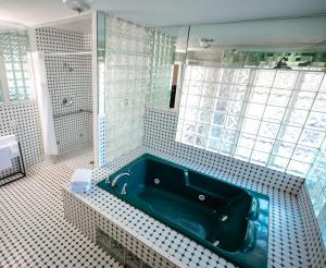 a bathroom with a blue tub and a shower at Suites by The Wellborn in Orlando +120 photos