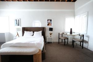 a bedroom with a bed and a table and chairs at Suites by The Wellborn in Orlando