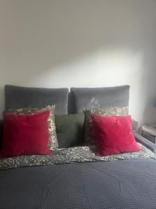een bed met twee rode kussens erop bij Bedroom in Paris in Parijs