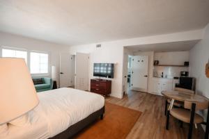 a bedroom with a bed and a desk and a table at Suites by The Wellborn in Orlando