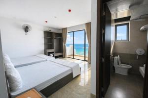 a bedroom with a bed and a view of the ocean at Sunrise Hotel Thiên Cầm in Ha Tinh +34 photos