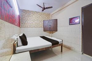 a small bed in a room with a wall at Hotel O Shivam In in New Delhi +21 photos