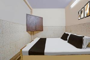 a bedroom with a bed with a cabinet on the wall at Hotel O Shivam In in New Delhi