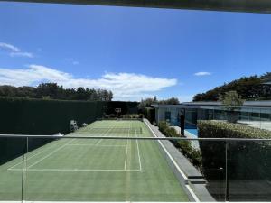 a tennis court with a tennis racket on it at Portsea Paramount - When only the best will do in Portsea