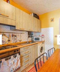 a kitchen with wooden cabinets and a table with chairs at Dimora del Viaggiatore Montecatini Terme in Serravalle Pistoiese