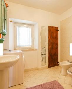 a bathroom with a sink and a toilet and a window at Dimora del Viaggiatore Montecatini Terme in Serravalle Pistoiese