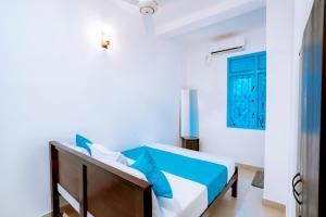 a bedroom with a bed with blue pillows at 75 Inn Madiha in Matara