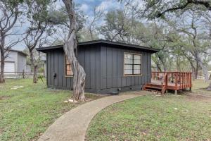 a black shed with a tree and a bench at Independence Bungalow in Wimberley