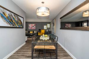 a dining room with a table and chairs in a living room at Stylish DT Condo ~2 Blocks from Stampede Grounds in Calgary