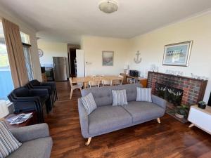 een woonkamer met een bank en een tafel bij River Panorama Beach House in Guilderton