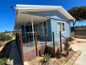 een blauw huis met een luifel erboven bij River Panorama Beach House in Guilderton +18 foto's