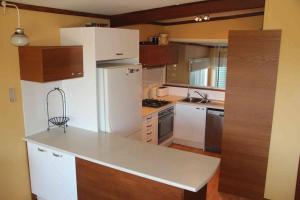 een keuken met een witte koelkast en houten kasten bij Gabbadah Beach House in Guilderton