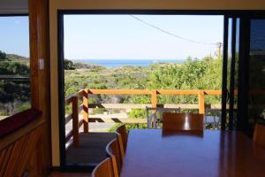 een eetkamer met een tafel en uitzicht op de oceaan bij Gabbadah Beach House in Guilderton