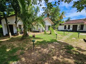 een binnenplaats van een gebouw met bomen ervoor bij Charitha Rest in Ampara