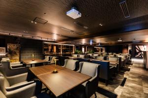 a dining room with wooden tables and chairs at APA Hotel Kanazawa Ekimae in Kanazawa