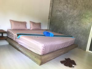 een bed met roze kussens en een blauwe handdoek erop bij Lantacocogarden in Ko Lanta Yai