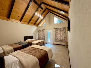 three beds in a room with wooden ceilings at Bungalows Bosque Selah in Nebaj