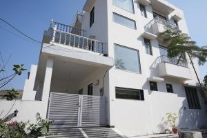 a white building with a balcony and a palm tree at Jagir villa in Udaipur
