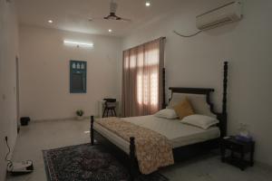 a bedroom with a bed and a window at Jagir villa in Udaipur