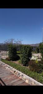 a wooden walkway with rocks on it with bushes at II Cerca de la playa y del centro in La Serena +6 photos
