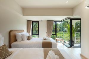 ein Schlafzimmer mit zwei Betten und einem großen Fenster in der Unterkunft ELYSIUM Villa Khao Lak in Khao Lak