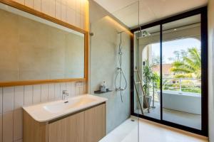 ein Badezimmer mit Waschbecken und Dusche in der Unterkunft ELYSIUM Villa Khao Lak in Khao Lak + 37 Fotos
