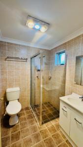 a bathroom with a toilet and a shower and a sink at Marulan Motor Inn in Marulan +44 photos