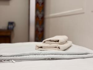 a pile of towels sitting on top of a bed at Ulli Oy Boutique & Terrace in Khiva +142 photos