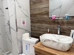 ein Badezimmer mit einem Marmorwaschbecken und einem WC in der Unterkunft Ulli Oy Boutique Hotel & Terrace in Xiva + 124 Fotos