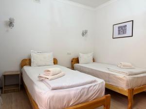 zwei Betten in einem Zimmer mit weißen Wänden in der Unterkunft Ulli Oy Boutique Hotel & Terrace in Xiva