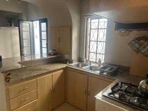 a kitchen with a sink and a stove in it at The College Suite, Mill Park in Gqeberha