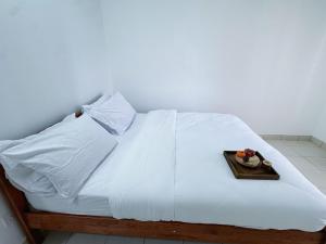 a white bed with a tray of fruit on it at PICC Seruling Precinct 5, 62200 Putrajaya 3BR Homestay in Putrajaya