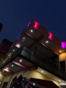 a building with purple lights on the top of it at Beach Residency in Kāsarkod +8 photos