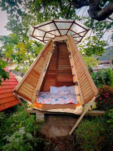 a wooden bed in a tree with a canopy at Tipi Miramelinda in Baños