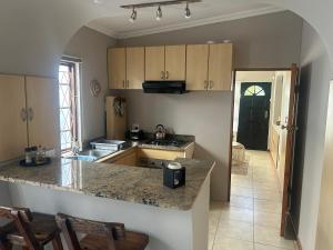 a kitchen with a sink and a counter top at The College Suite, Mill Park in Gqeberha