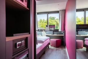 a room with a bed and a desk with a tv at SMARTY Leichlingen-Cologne - KONTAKTLOSER SELF CHECK-IN in Leichlingen