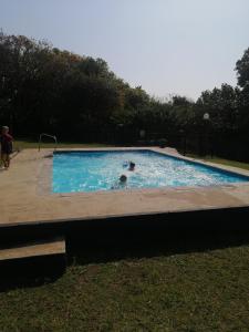 a couple of people in a swimming pool at Angers Aweigh, Hibberdene Chalet 86 in Hibberdene