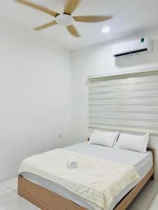 a bedroom with a bed with a ceiling fan at My Homestay in Tuaran +11 photos